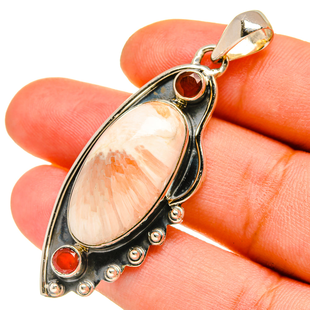 Sterling silver pendant close-up with peach teardrop stone and red round cabochons