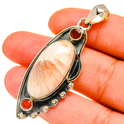 Sterling silver pendant close-up with peach teardrop stone and red round cabochons