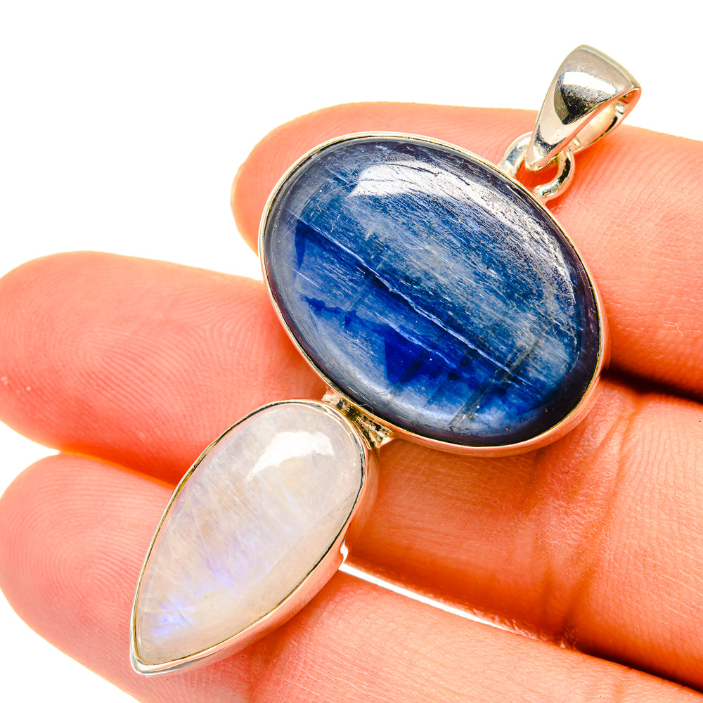 Blue oval gemstone pendant with iridescent white oval stone in silver setting