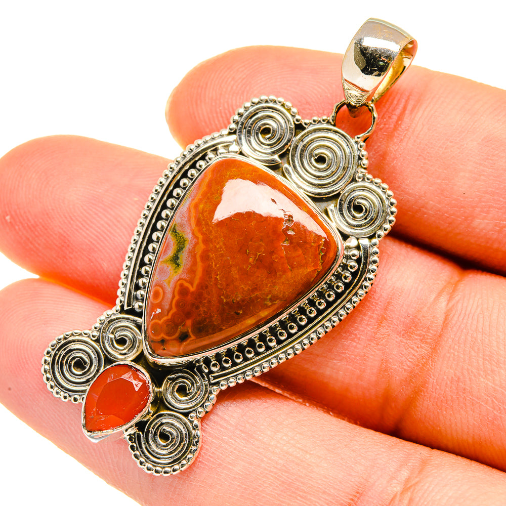 Heart-shaped orange-red jasper pendant with sterling silver swirl frame and bail