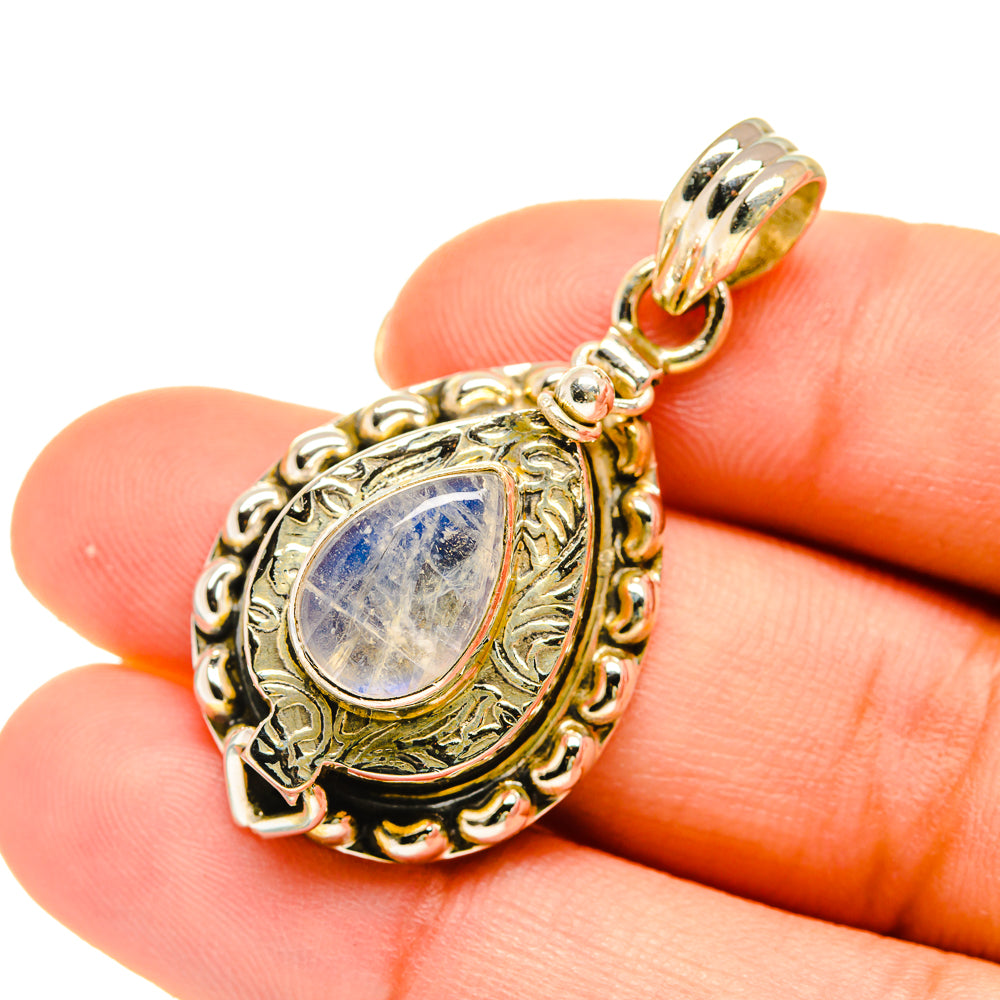 Moonstone teardrop pendant on bail, shown on hand for size, ornate gold-tone setting