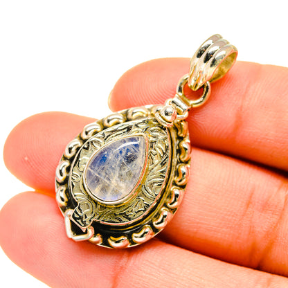 Moonstone teardrop pendant on bail, shown on hand for size, ornate gold-tone setting