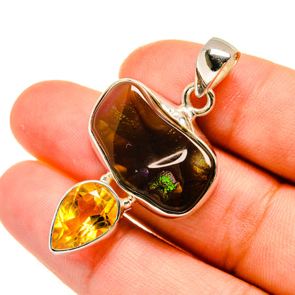 Fire agate and citrine pendant with silver bail, worn look on hand