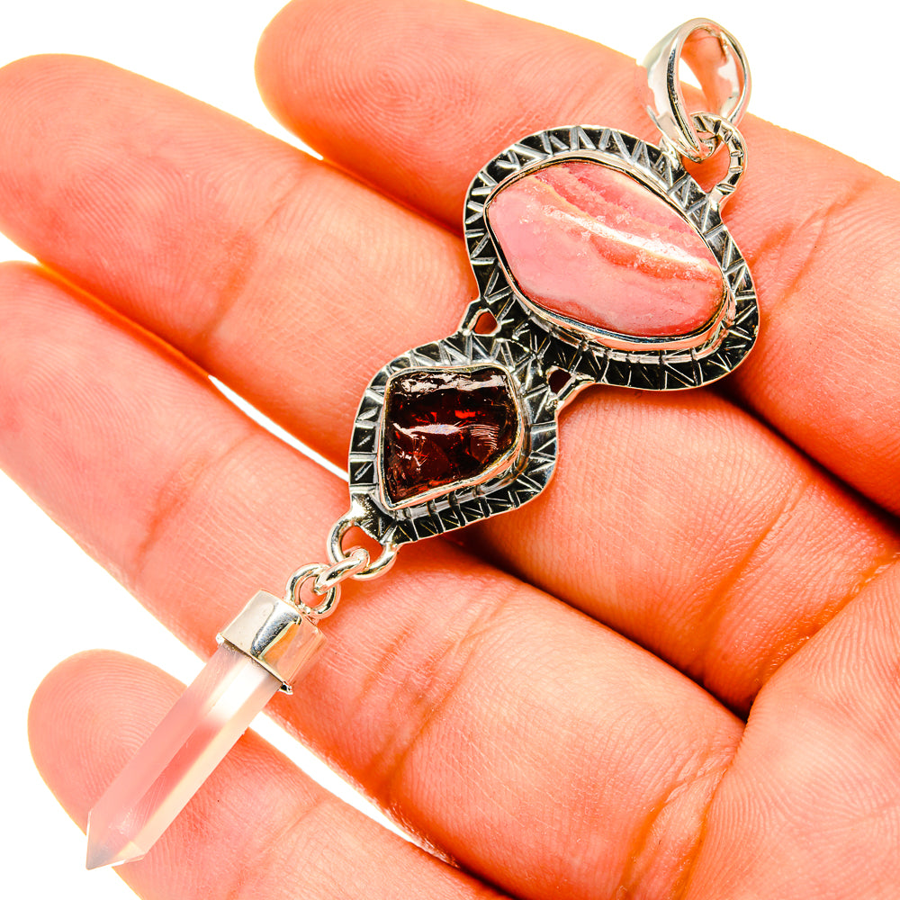 Pink oval stone and dark red heart stone pendant with ornate silver bail and chain clasp.