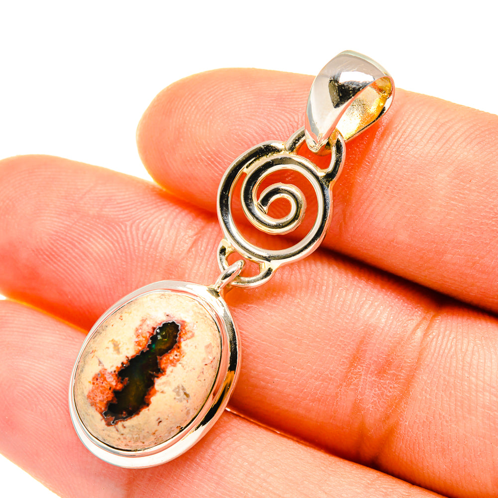 Sterling silver pendant with round fire opal stone and swirl halo, close-up