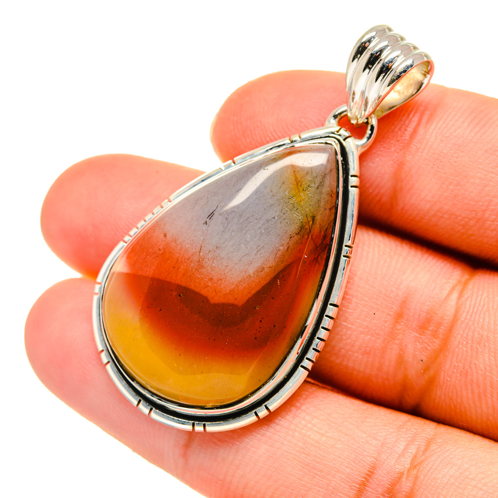 Sterling silver jasper teardrop pendant on hand, orange-red cabochon stone