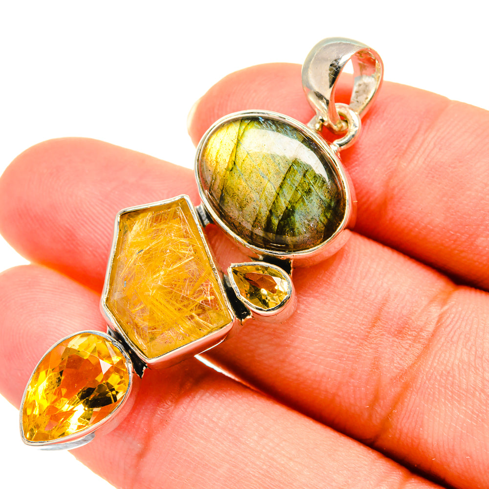 Sterling silver gemstone pendant in hand: labradorite center, citrine faceted pieces