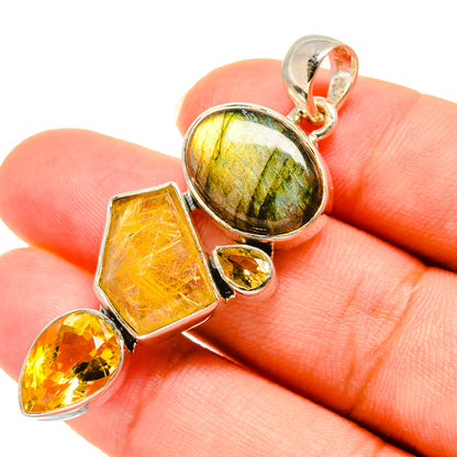 Sterling silver gemstone pendant in hand: labradorite center, citrine faceted pieces