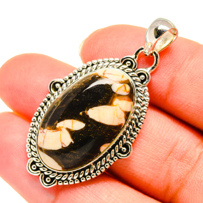 Jasper pendant in oval bezel, black and tan marbled stone with ornate silver frame