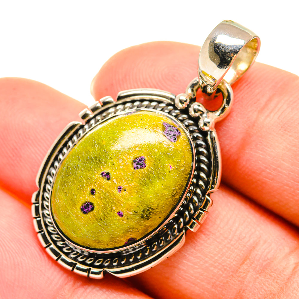 Oval yellow-green gemstone pendant with purple specks, sterling silver setting and small orange bead