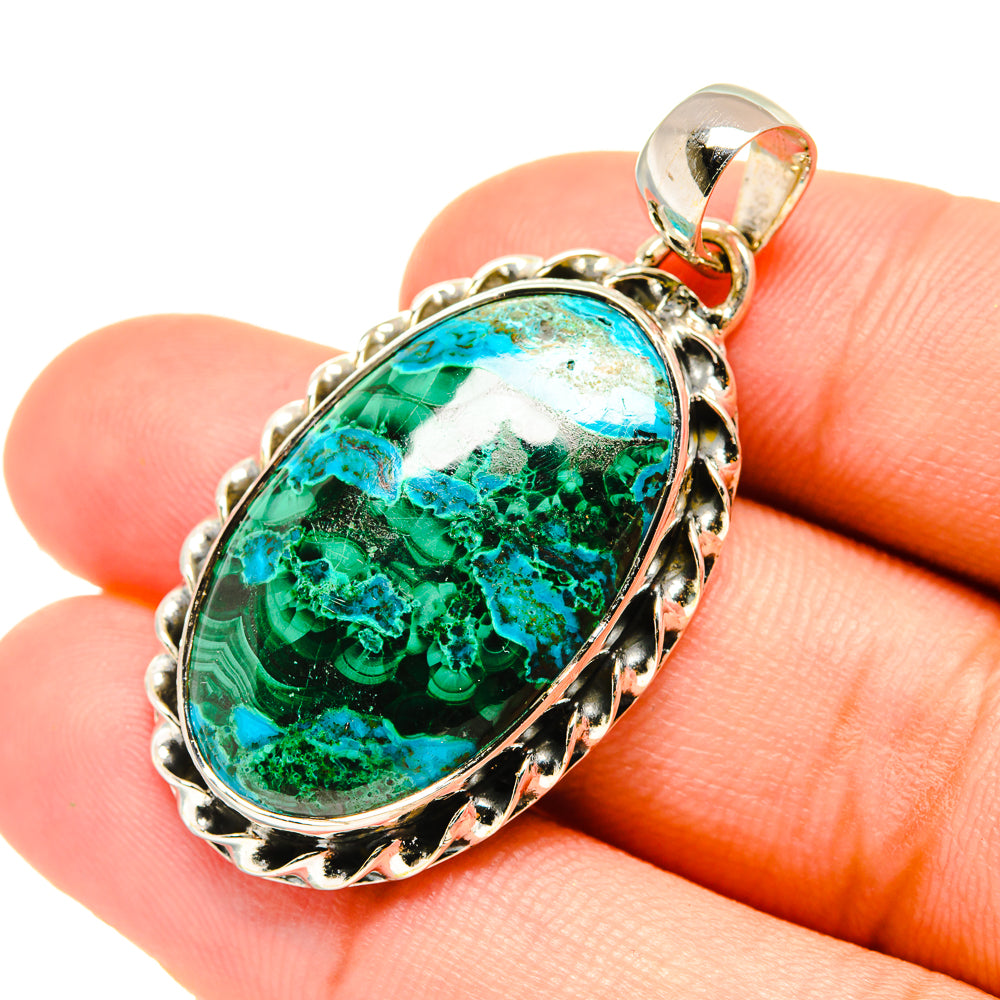 Green-blue oval gemstone pendant close-up on silver-tone setting and bail