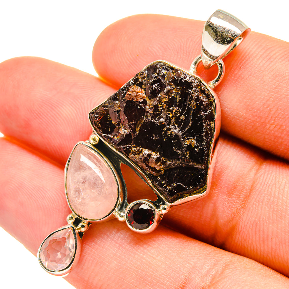 Sterling silver pendant with rough dark stone center, pink teardrop accents, bail