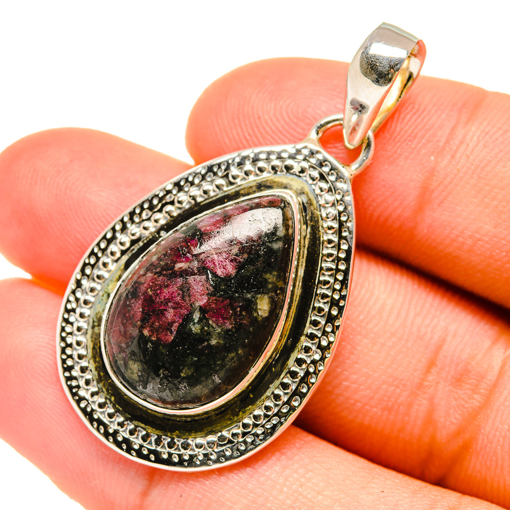 Ornate silver teardrop pendant with marbled black and red eudialyte stone