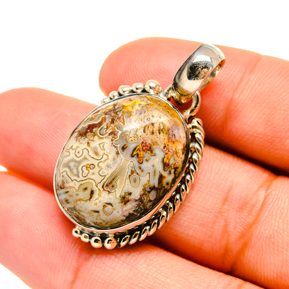 Sterling silver oval agate pendant with bail; shown held in hand