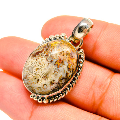 Sterling silver oval agate pendant with bail; shown held in hand