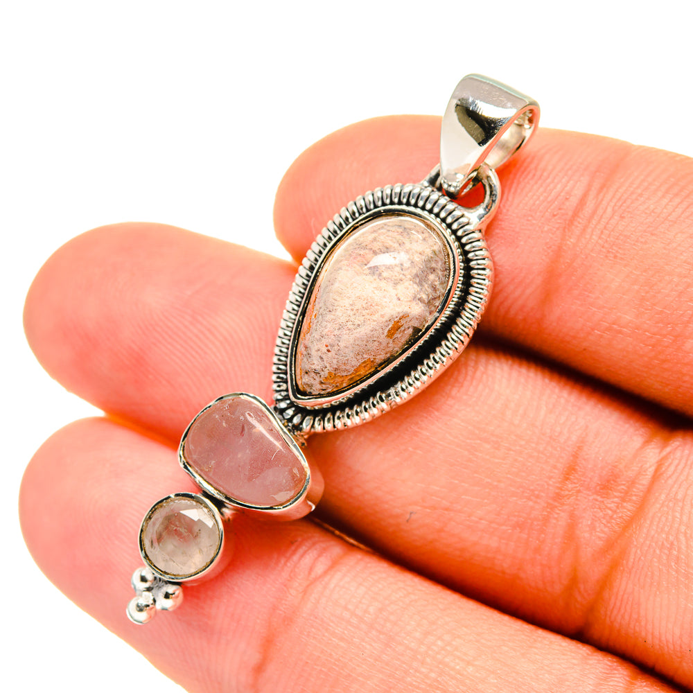 Sterling silver oval orange stone pendant with two rose-pink bezel settings