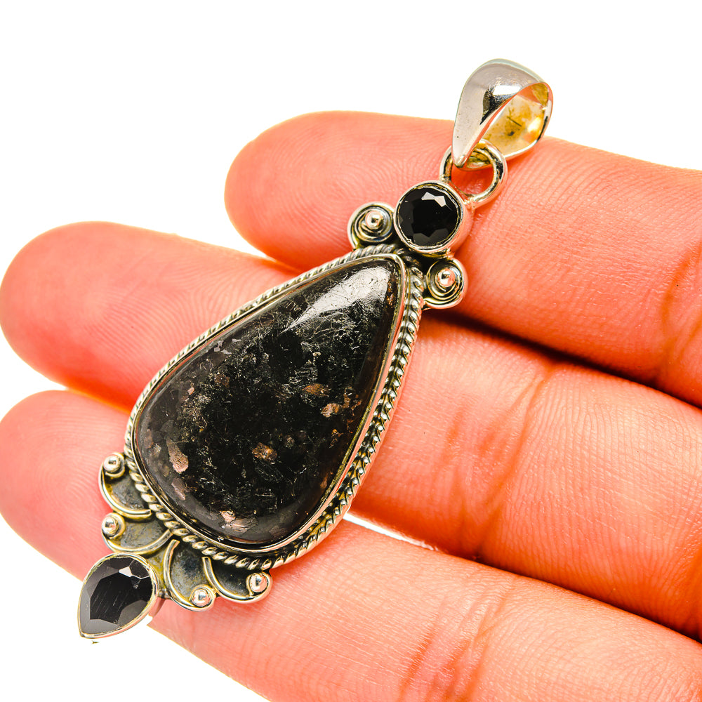 Sterling silver teardrop gemstone pendant with black onyx detail, close-up on hand