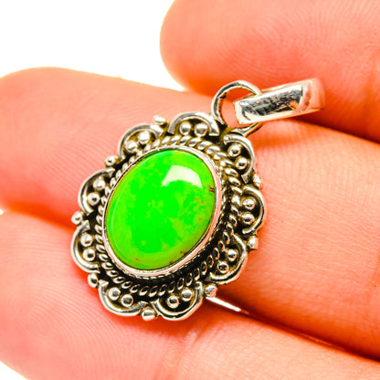 Close-up green oval turquoise pendant with ornate silver-tone border and bail