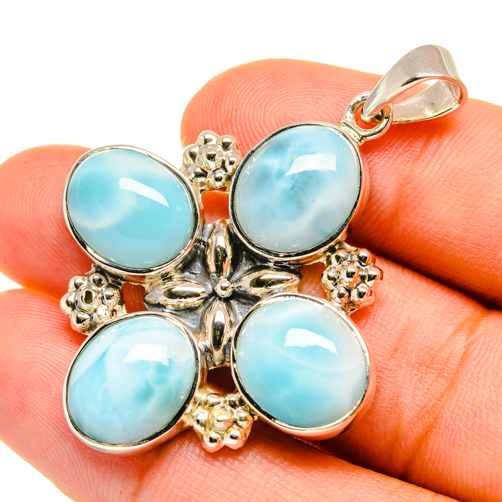 Sterling silver pendant with four round light-blue cabochons and ornate bail top