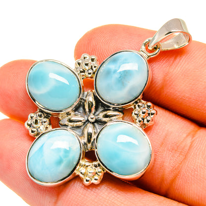 Sterling silver pendant with four round light-blue cabochons and ornate bail top