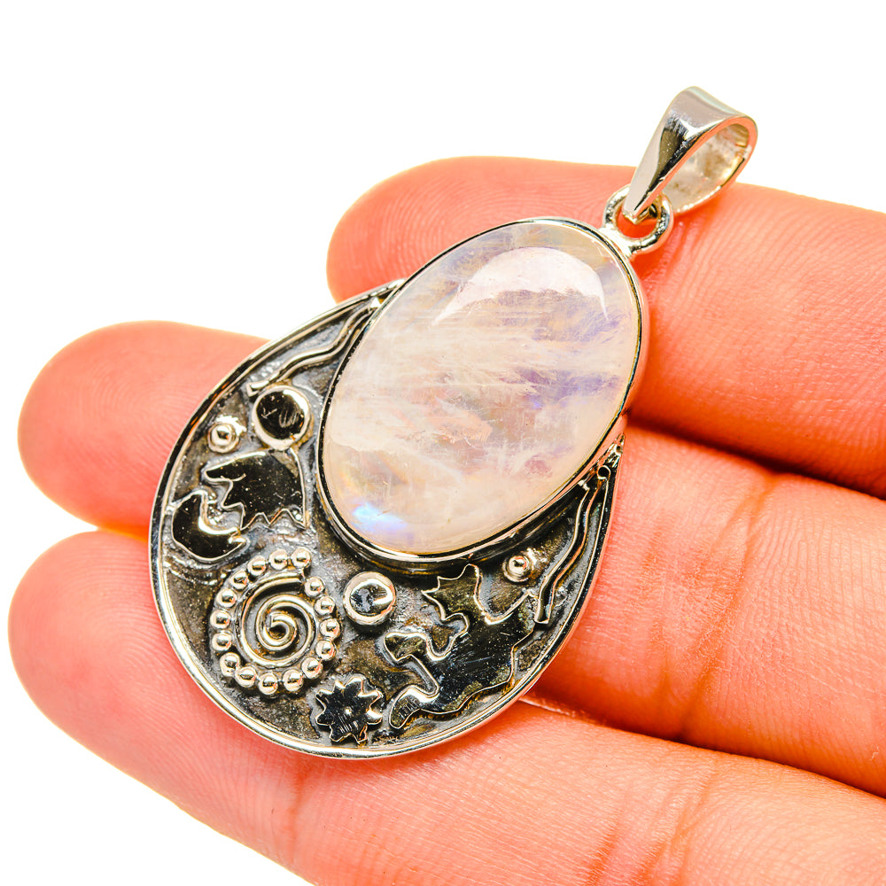 Opalescent oval moonstone pendant in sterling silver with filigree border and bail
