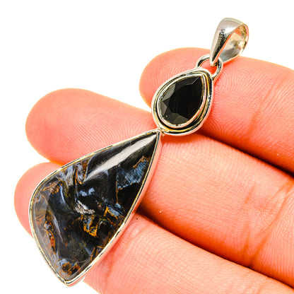 Sterling silver teardrop pendant with black onyx-style gemstone and gold-toned bezel