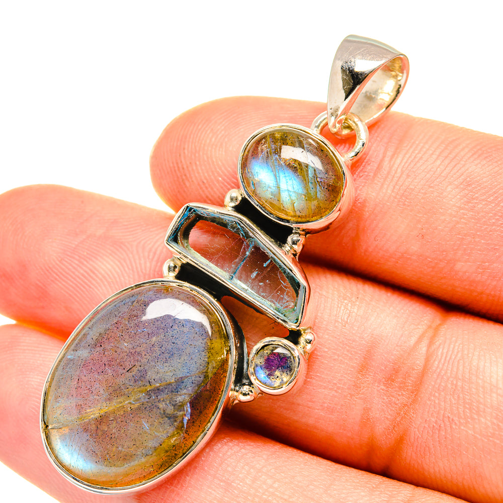 Sterling silver pendant close-up with oval labradorite, square aquamarine, and small blue gems