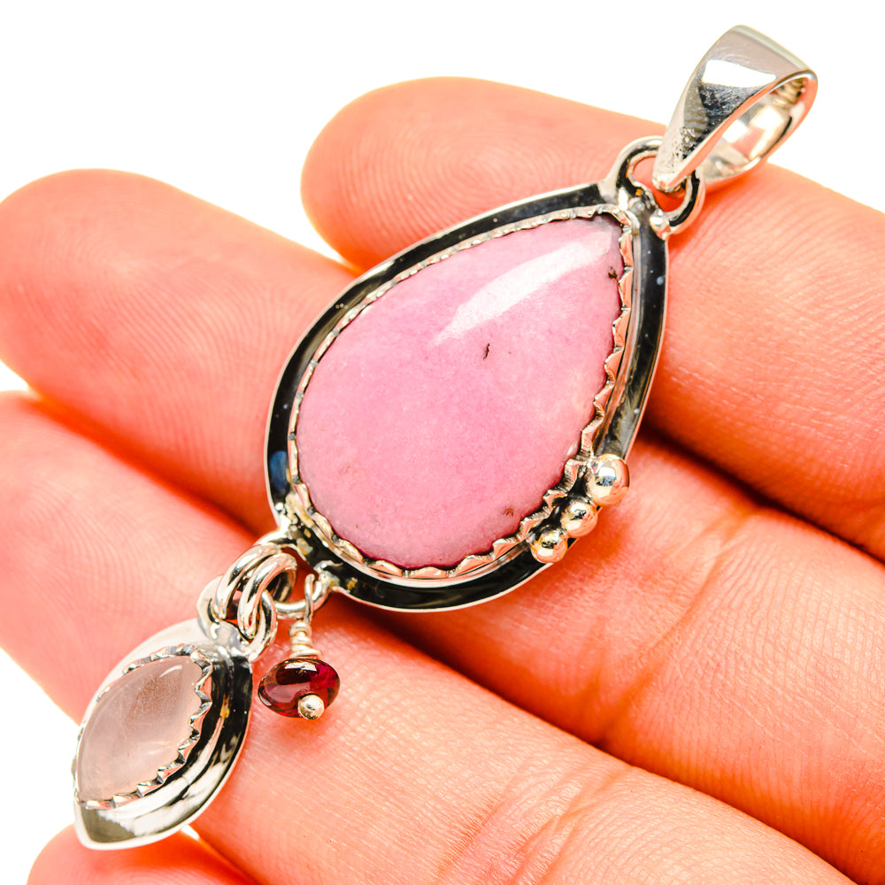 Teardrop pink gemstone pendant in silver bezel with small dangling stones