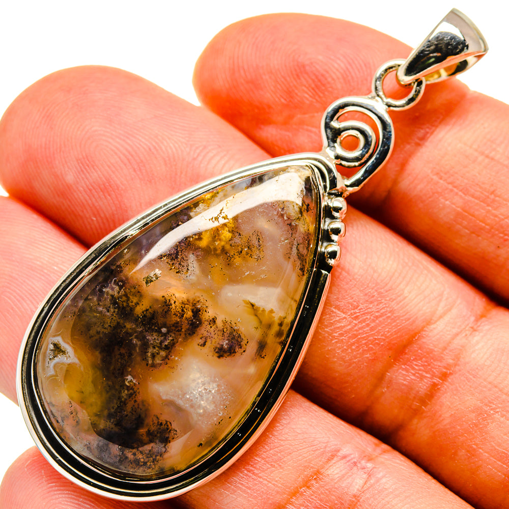 Agate pendant close-up, teardrop cabochon with amber, gray, and dark speckles; silver bail