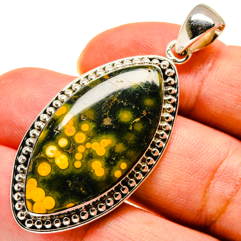 Oval gemstone pendant, green with yellow dot pattern, sterling silver setting