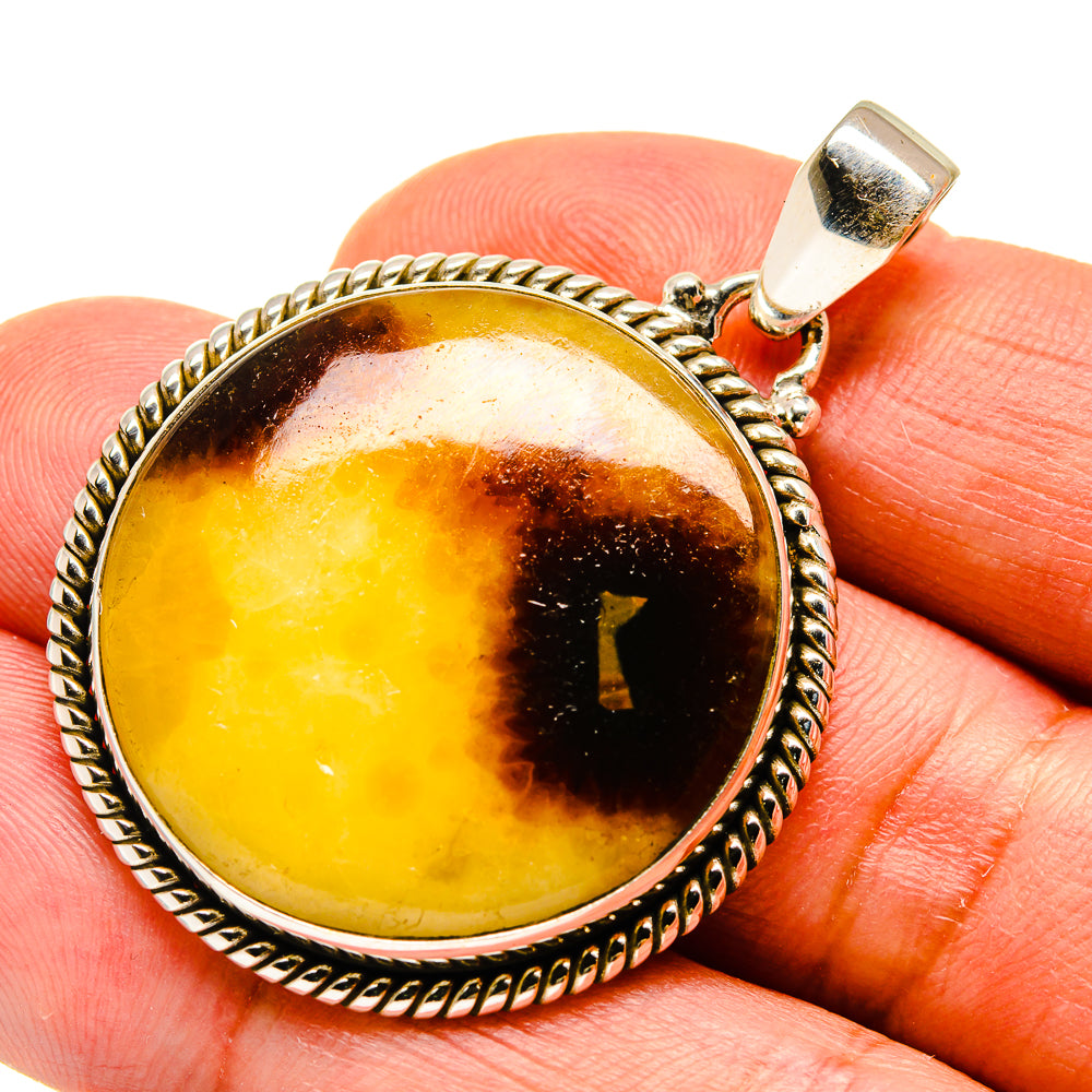Septarian nodule pendant in silver with round amber-yellow stone and dark streaks