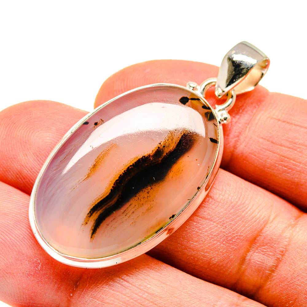 Oval Montana agate pendant with silver bezel, peach-pink stone and dark swirl band, top bail