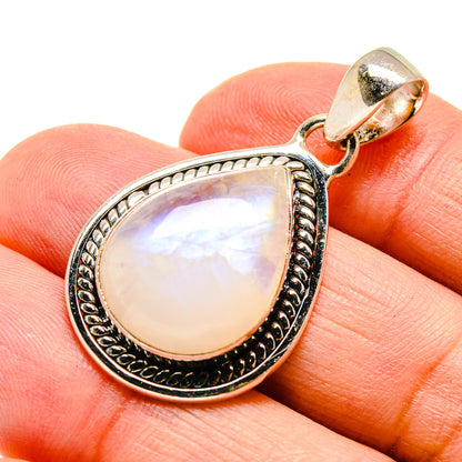Teardrop moonstone pendant close-up, iridescent opal-like white with silver-tone trim.