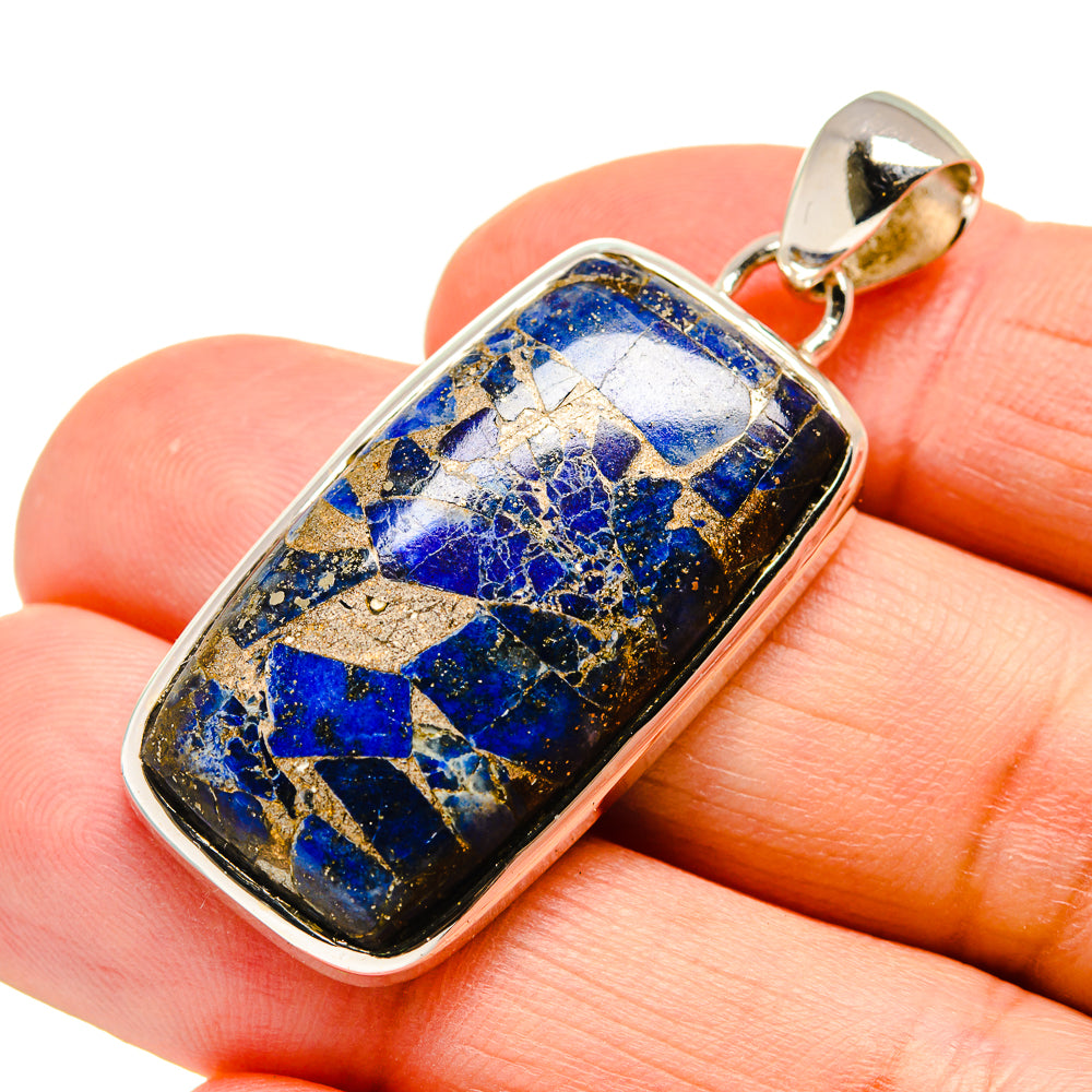 Lapis lazuli pendant detail on stone bezel, blue flecked rectangle with gold bail
