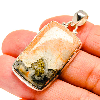 Scolecite pendant in silver frame with orange and cream stone and dark speckled inclusions