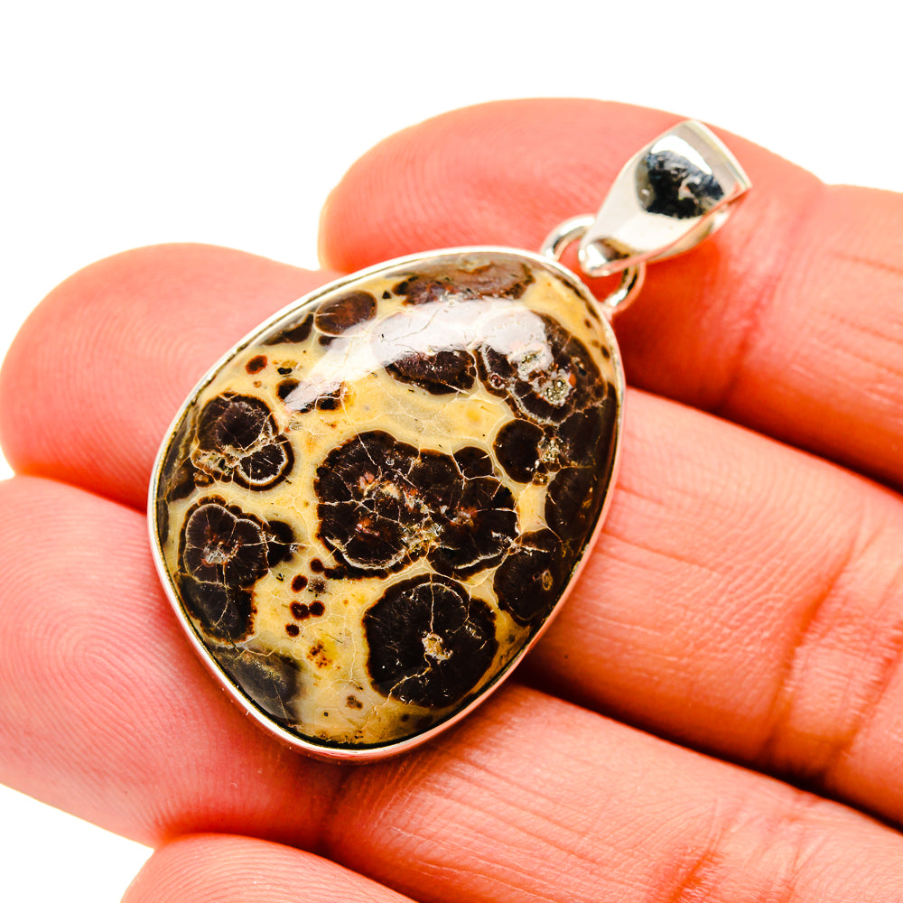 Heart-shaped poppy jasper pendant with silver bail, black and tan stone.