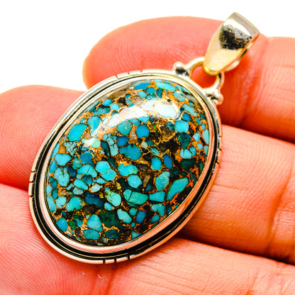 Oval turquoise pendant close-up with gold bail and sterling-silver bezel, blue mosaic stone