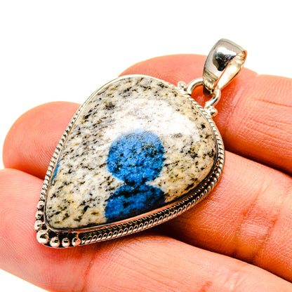 Blue teardrop stone pendant with bail and textured edge in silver setting