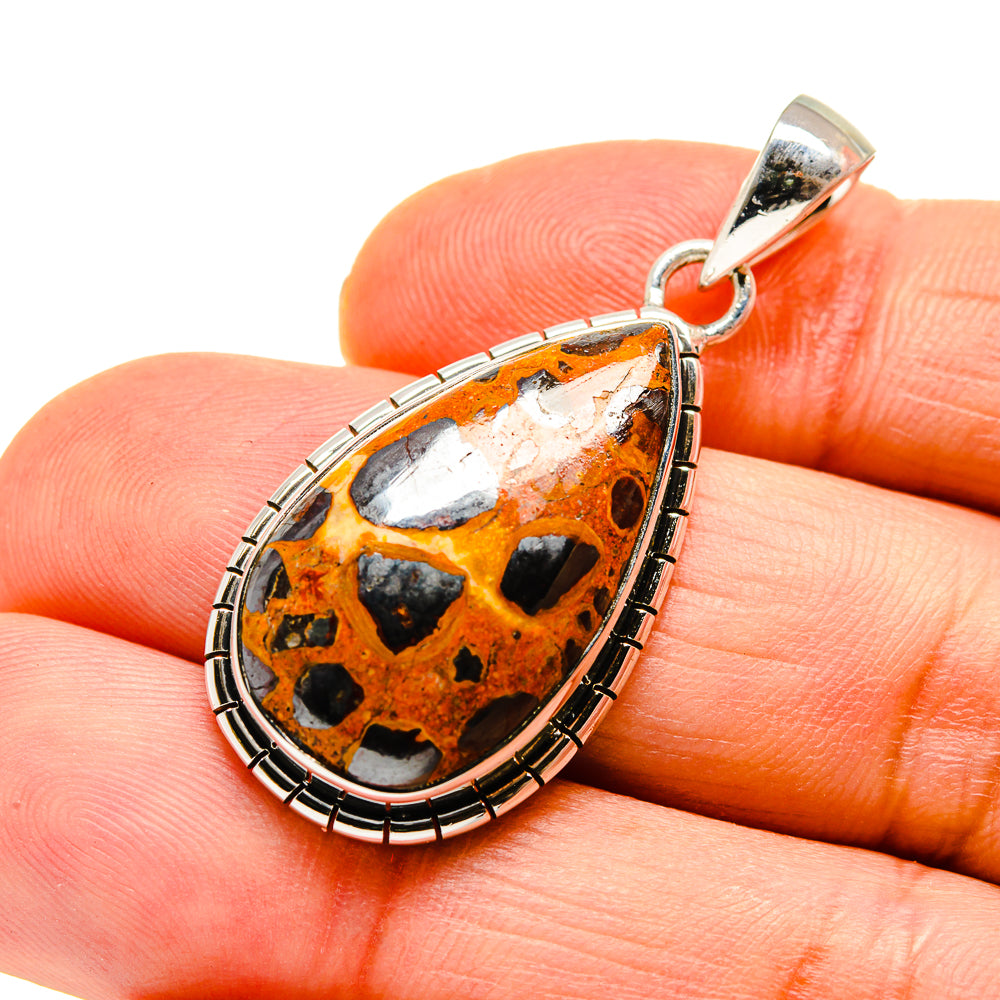 Teardrop chert breccia pendant close-up with orange, black, white stone and silver bail