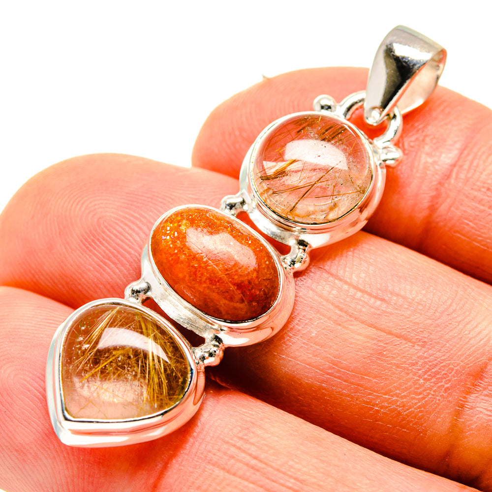 Oval gemstone pendant in sterling silver, three stones on finger: rutilated quartz and sunstone