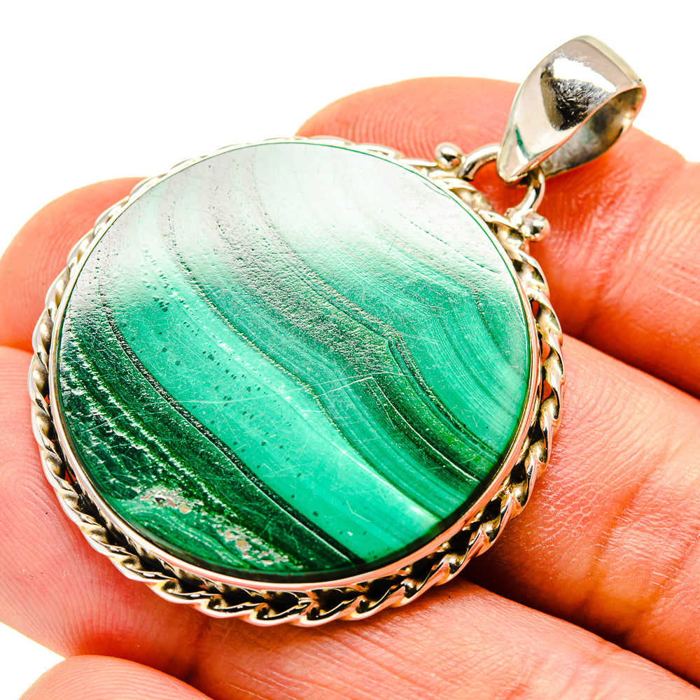 Malachite pendant close-up on faceted green stone with textured silver-tone frame