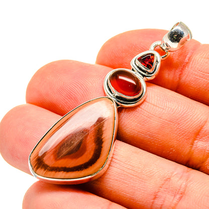 Teardrop gemstone pendant with silver bezel; red cabochons and amber stone