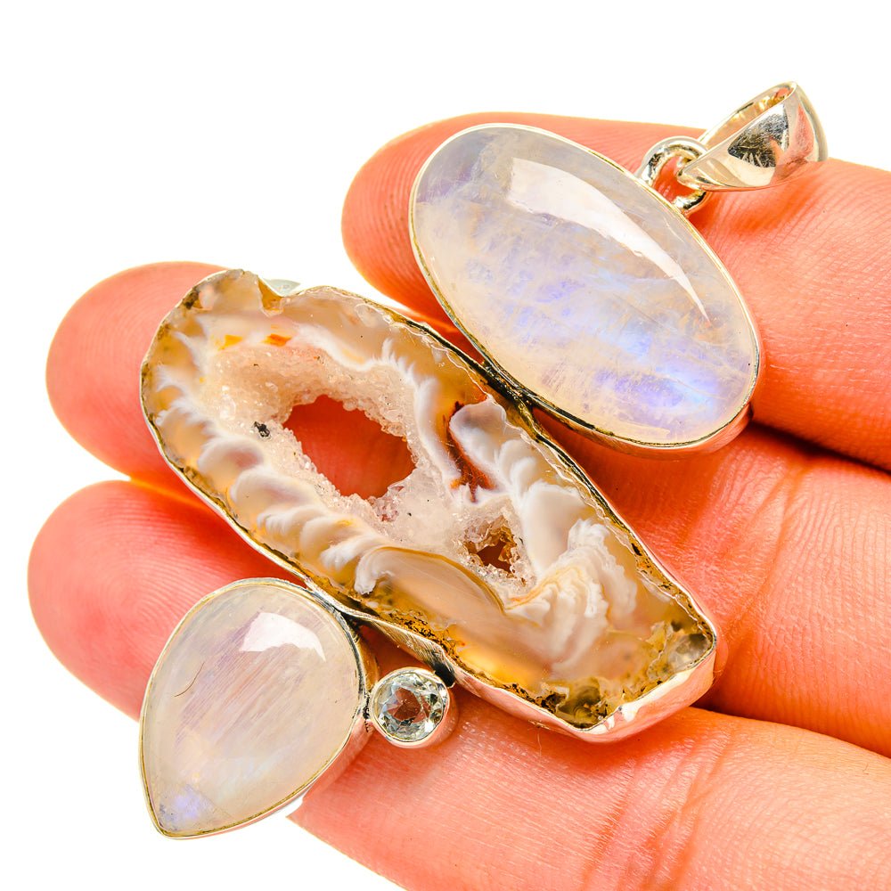 Geode-slice pendant with iridescent opal-like stone and two small round cabochons, silver bail