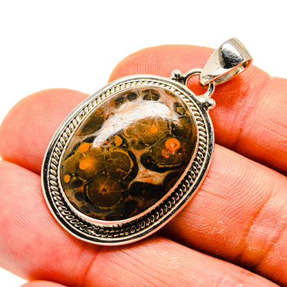 Silver-tone jasper pendant with round orange-brown cabochon and ornate bezel