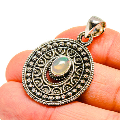 Sterling silver opal pendant with ornate round bezel and iridescent cabochon