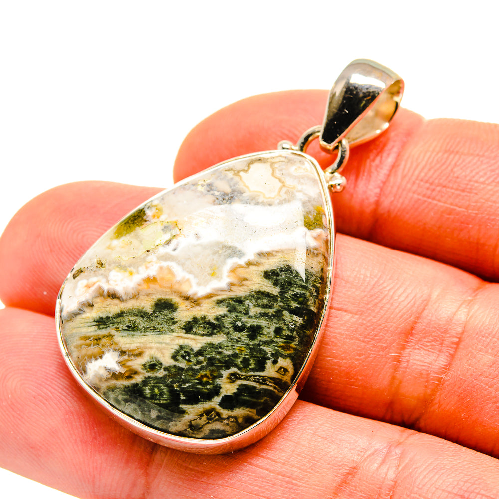 Oval ocean jasper pendant in silver bezel with gold-toned bail.