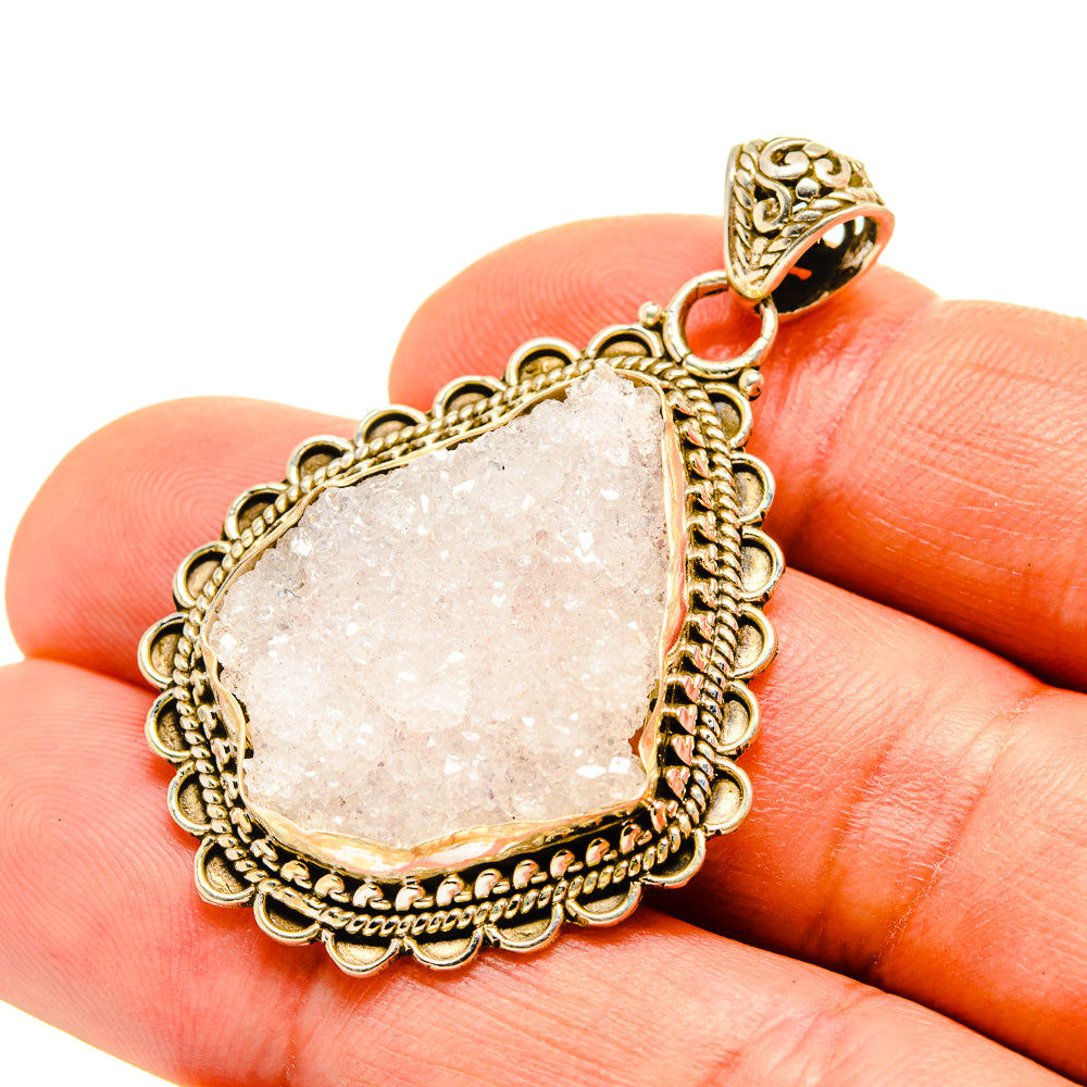 Rough moonstone pendant with ornate gold-tone frame and small red accent bail