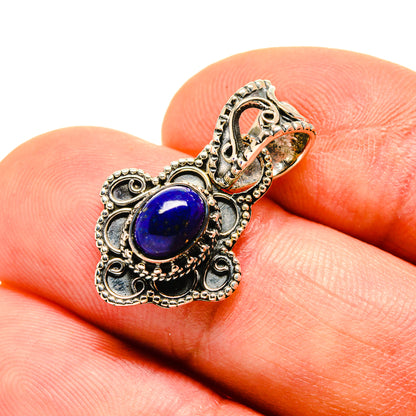 Lapis lazuli pendant in antique silver with blue oval stone and ornate filigree