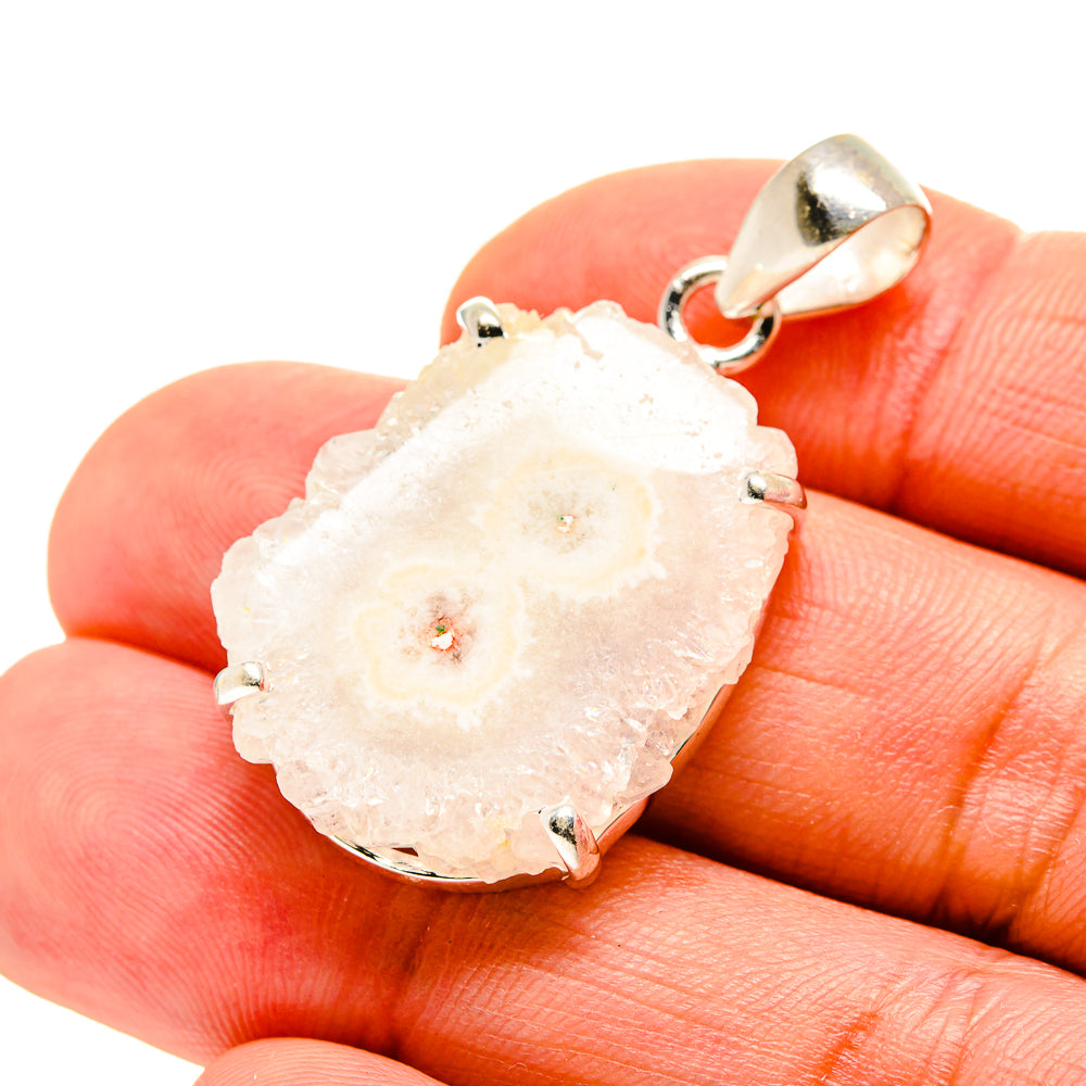 White solar quartz pendant with silver bail on hand, facet edge details