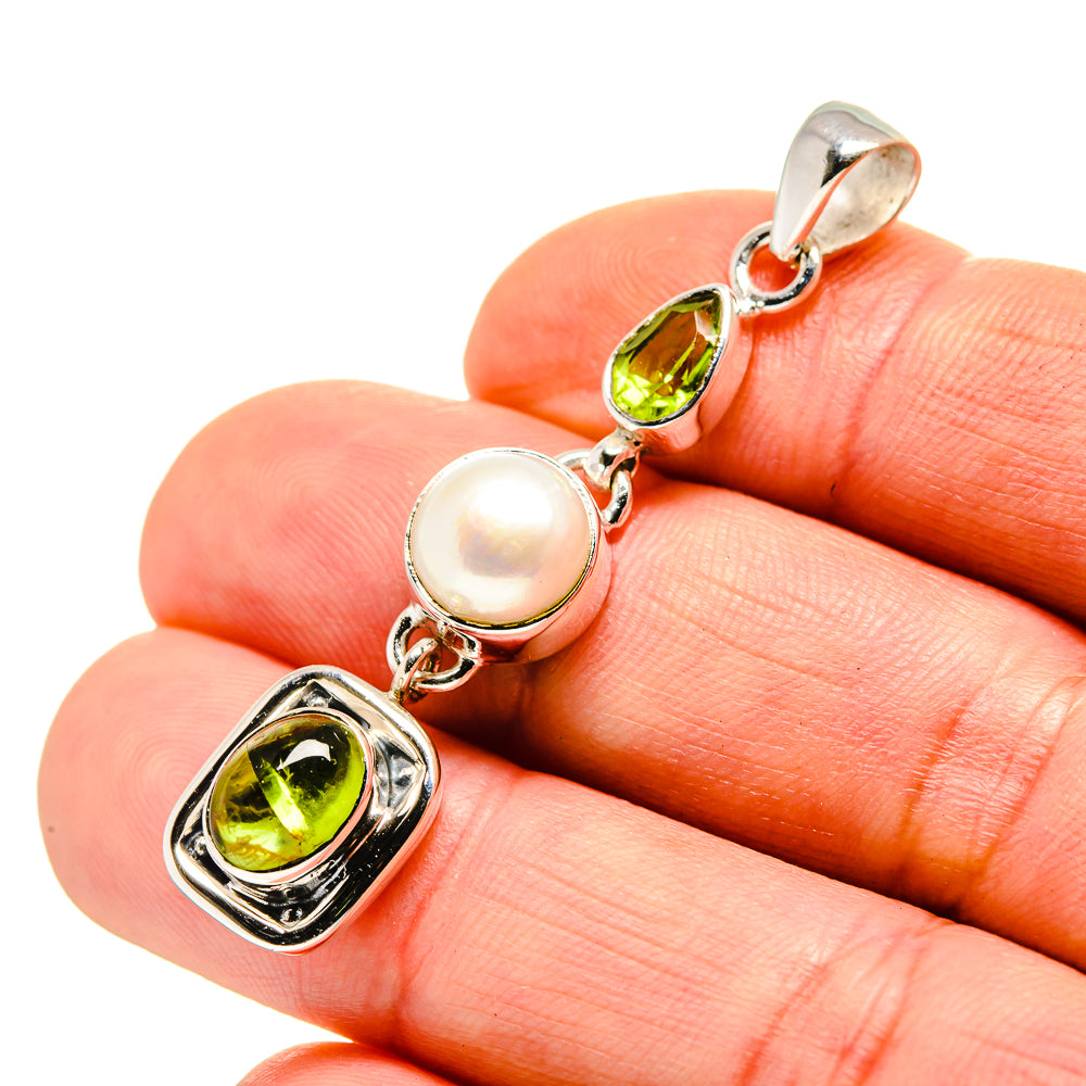 Sterling silver pendant with cultured pearl and green peridot gemstones, close-up
